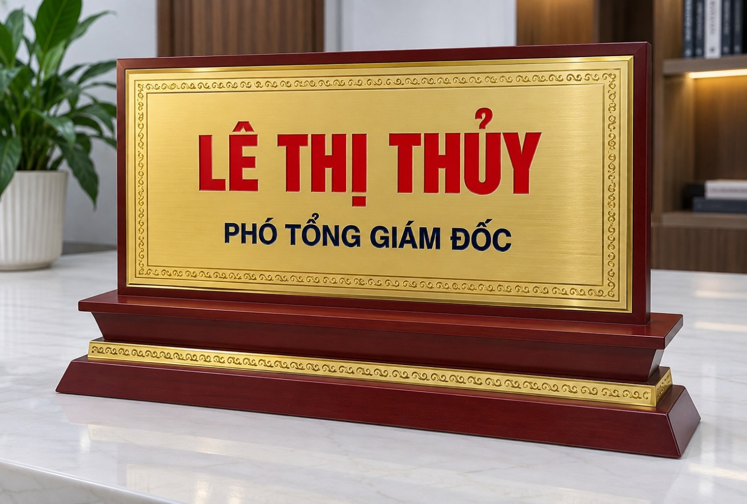 Biển chức danh để bàn inox mạ vàng viền hoa văn đế gỗ mun đỏ, khắc tên Lê Thị Thủy - Phó Tổng giám đốc, chữ đỏ và xanh nổi bật