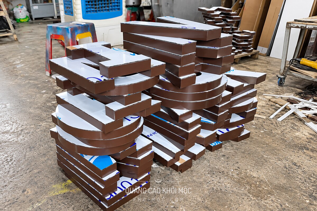 Chữ nổi alu bán thành phẩm màu nâu đồng xếp chồng tại xưởng
